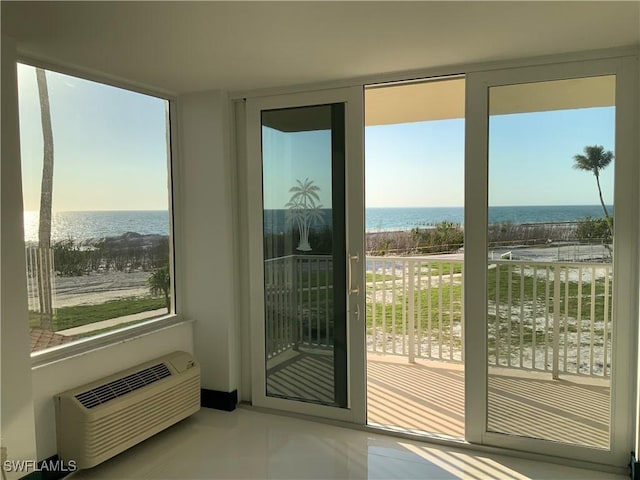 doorway to outside featuring a water view, a healthy amount of sunlight, and an AC wall unit