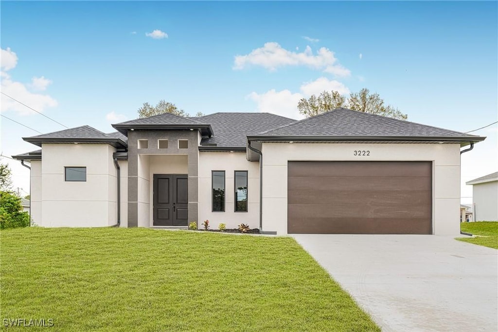 prairie-style house featuring a front lawn and a garage