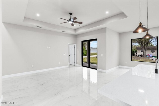 unfurnished room featuring ceiling fan and a tray ceiling