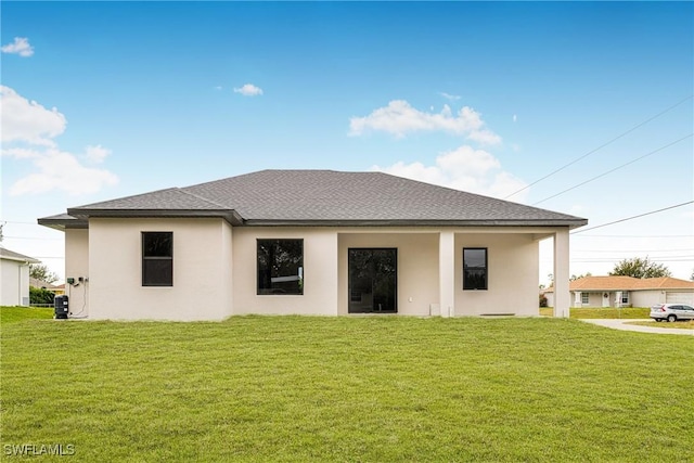 rear view of property featuring a lawn