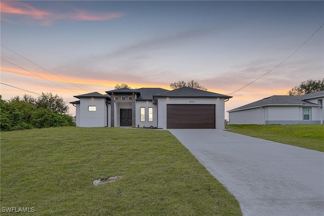 view of front of home with a garage and a yard