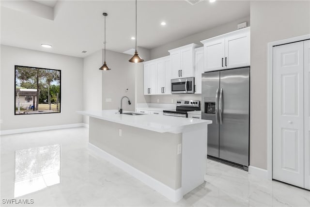 kitchen with a center island with sink, appliances with stainless steel finishes, white cabinets, decorative light fixtures, and sink