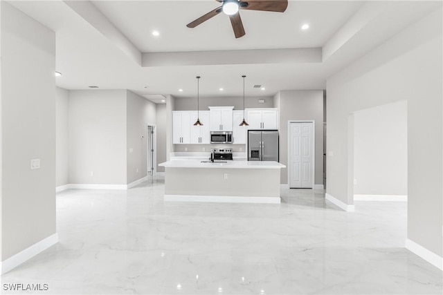 kitchen with decorative light fixtures, a kitchen island with sink, white cabinets, and appliances with stainless steel finishes