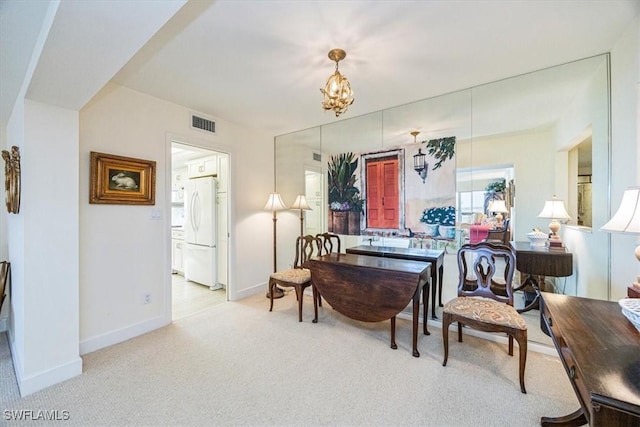 sitting room featuring light colored carpet and a notable chandelier