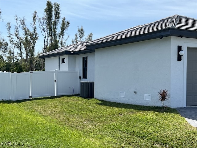 view of side of home with cooling unit and a yard