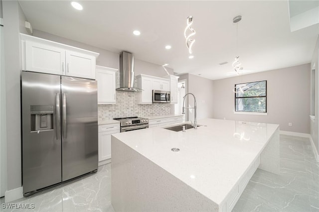 kitchen with wall chimney exhaust hood, stainless steel appliances, an island with sink, and white cabinets