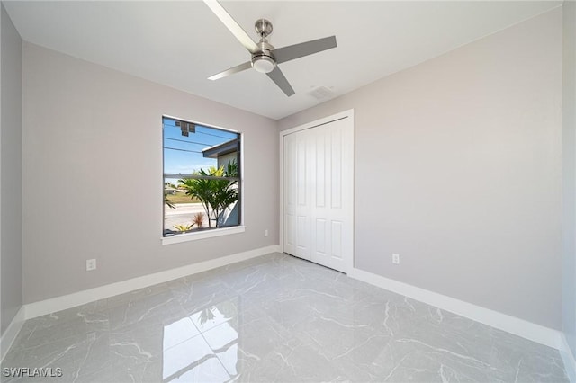 unfurnished bedroom with ceiling fan and a closet