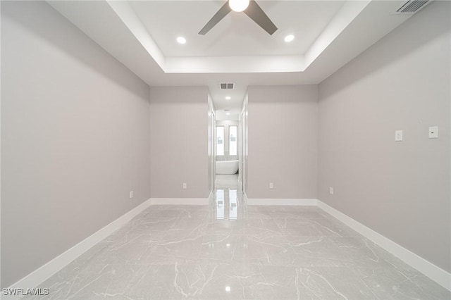 unfurnished room featuring ceiling fan and a tray ceiling