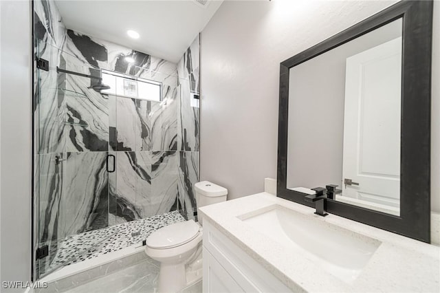 bathroom featuring vanity, toilet, and a shower with shower door