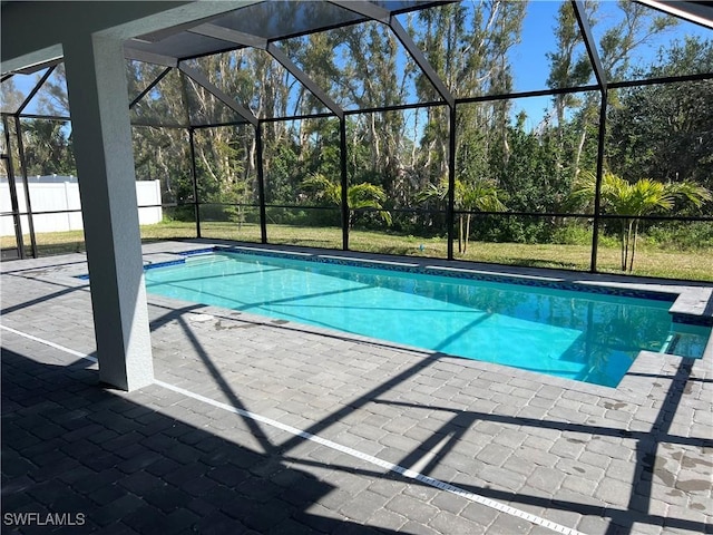 view of pool featuring a lanai, a patio area, and a lawn