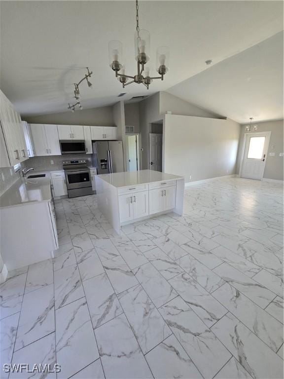 kitchen featuring an inviting chandelier, stainless steel appliances, white cabinets, decorative light fixtures, and sink