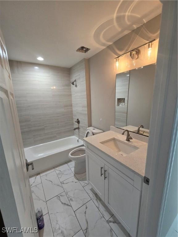 full bathroom with tiled shower / bath combo, vanity, and toilet