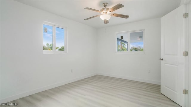 spare room with light hardwood / wood-style floors, ceiling fan, and a healthy amount of sunlight