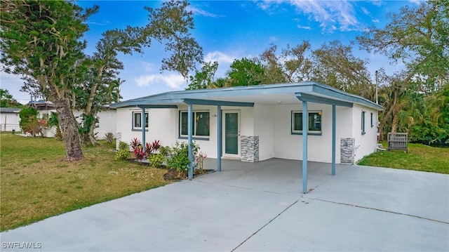 view of front of property with a front yard and a carport