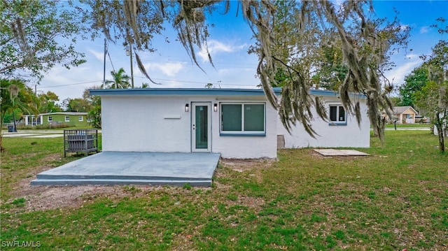 back of property featuring a yard and a patio