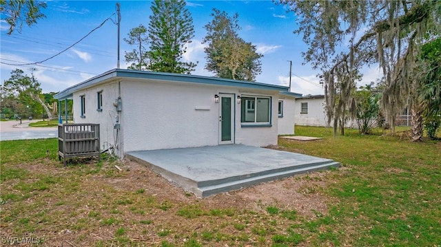 rear view of house featuring a yard and a patio