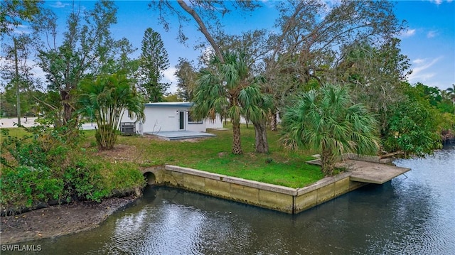 exterior space featuring a yard, a water view, and a patio