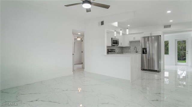 unfurnished living room featuring ceiling fan and sink