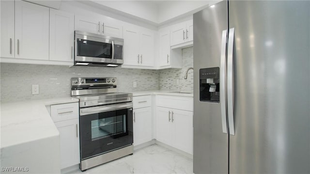 kitchen featuring decorative backsplash, sink, white cabinetry, and stainless steel appliances