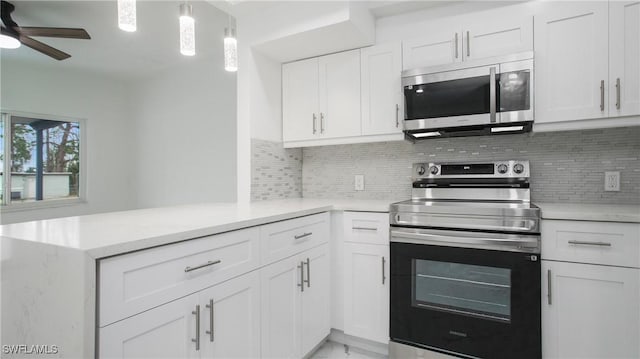 kitchen featuring kitchen peninsula, appliances with stainless steel finishes, decorative backsplash, and white cabinetry