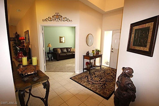 corridor featuring high vaulted ceiling and light tile patterned flooring