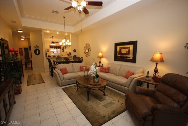 tiled living room featuring crown molding, ceiling fan with notable chandelier, and a tray ceiling