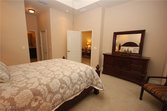 carpeted bedroom with a towering ceiling