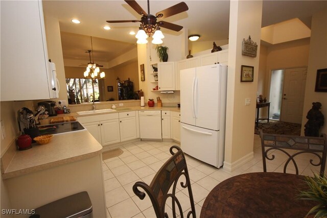 kitchen with sink, white appliances, light tile patterned floors, white cabinets, and decorative light fixtures