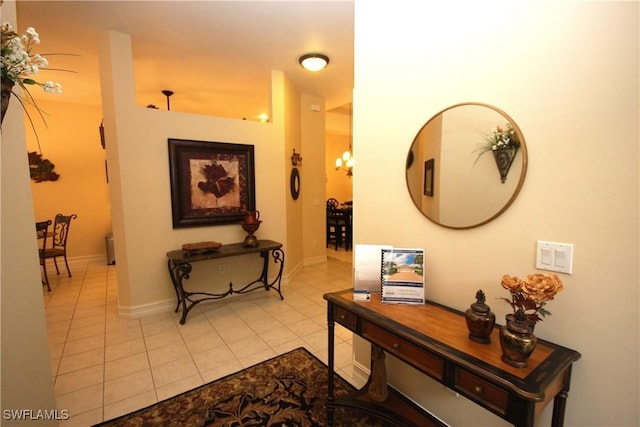 corridor featuring light tile patterned floors and a notable chandelier