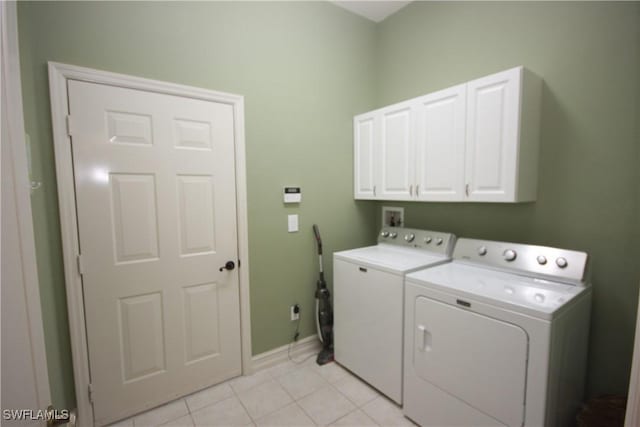 clothes washing area featuring cabinets, light tile patterned floors, and independent washer and dryer