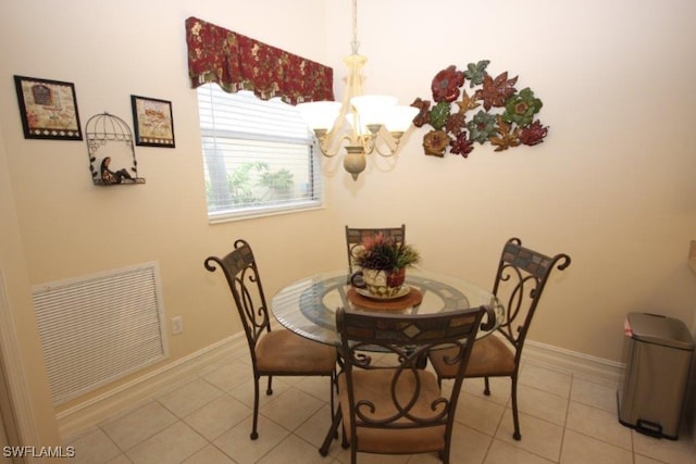 tiled dining room with a chandelier