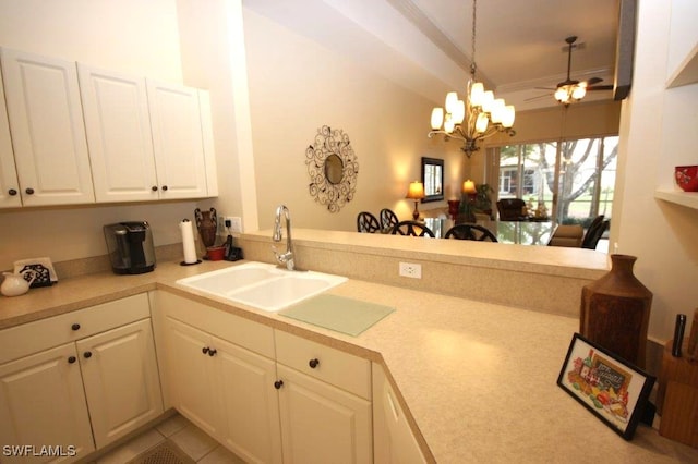 kitchen featuring sink, kitchen peninsula, white cabinets, and decorative light fixtures