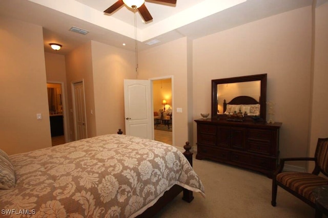 carpeted bedroom featuring a tray ceiling and ceiling fan