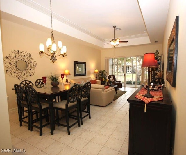 tiled dining room featuring a raised ceiling, crown molding, and ceiling fan with notable chandelier