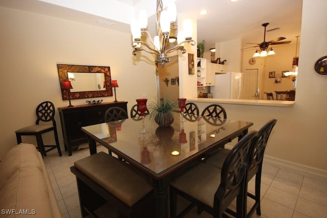 dining room with light tile patterned floors and ceiling fan with notable chandelier