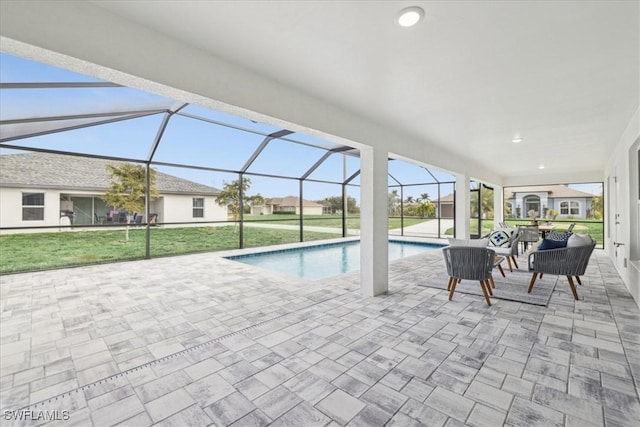 view of pool with a yard, glass enclosure, and a patio area