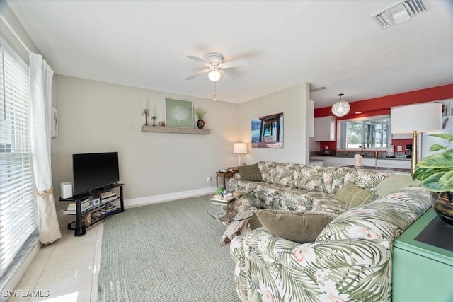 tiled living room featuring ceiling fan and a healthy amount of sunlight