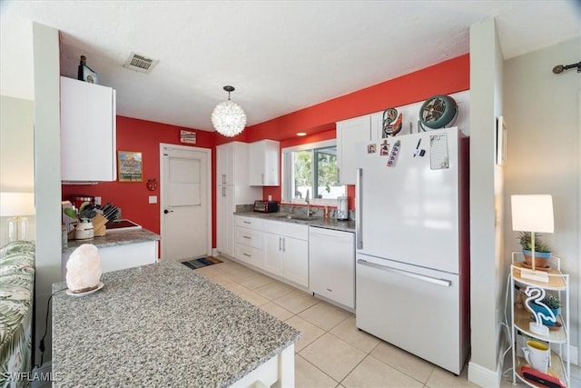 kitchen featuring pendant lighting, sink, white appliances, white cabinetry, and light tile patterned floors