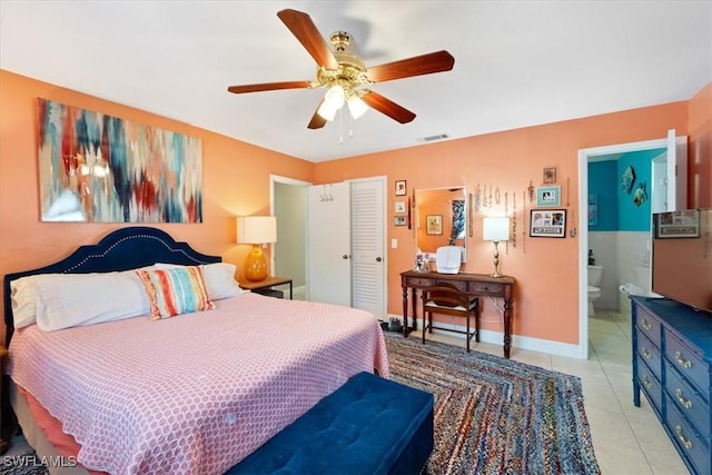 tiled bedroom with ceiling fan and ensuite bath