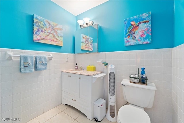 bathroom featuring toilet, tile patterned flooring, tile walls, and vanity