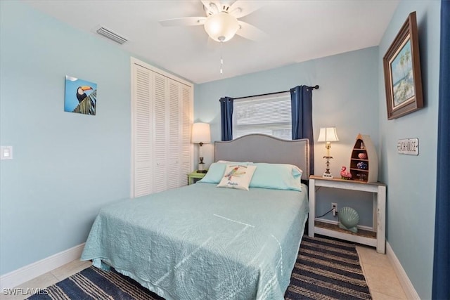 tiled bedroom with ceiling fan and a closet