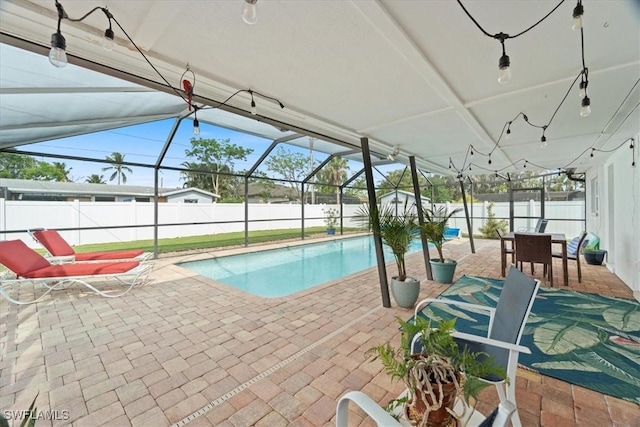 view of swimming pool with glass enclosure and a patio