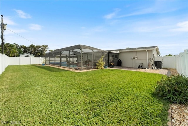 view of yard featuring a fenced in pool and glass enclosure