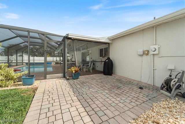 view of patio featuring glass enclosure