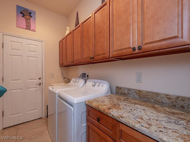 laundry room with cabinets, washer and clothes dryer, and light tile patterned floors