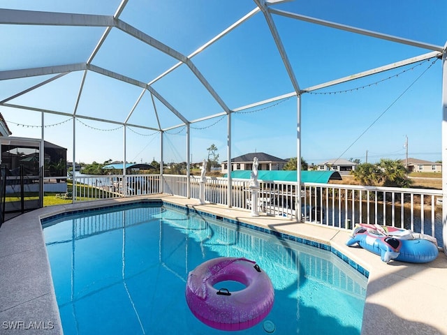 view of swimming pool featuring a water view, a patio area, and glass enclosure