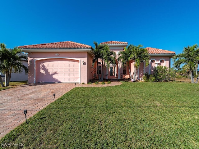 mediterranean / spanish-style house featuring a garage and a front yard