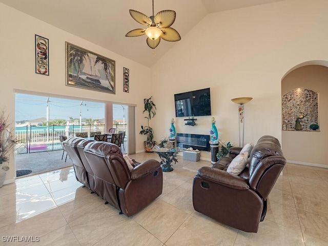 living room with light tile patterned flooring, ceiling fan, and high vaulted ceiling