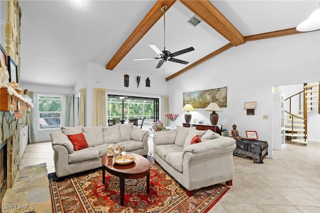 tiled living room featuring high vaulted ceiling, a wealth of natural light, beam ceiling, and a stone fireplace