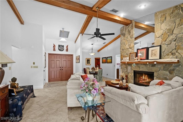 living room with ceiling fan, beam ceiling, light tile patterned floors, a stone fireplace, and high vaulted ceiling